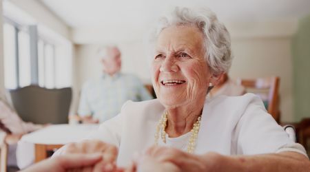 Senior lady living in a residential aged care community is assisted by a carer.